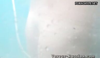 Обнаженная девушка принимает душ после жаркого дня на пляже