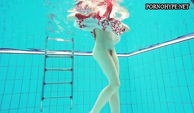 Горячая рыжая молодка плавает в бассейне голышом